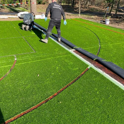 Kunstgras speelvloeren 98 Aanleg grote sportkooi bij de Paalberg, het insnijden van de belijningen en het leggen van de kunstgras speelvloer